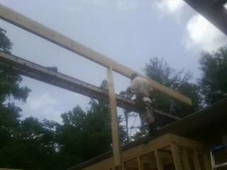 Carpenter setting a ridge beam over a new addition frame — Ice Dam Removal by Roofing Brothers in East Ellijay