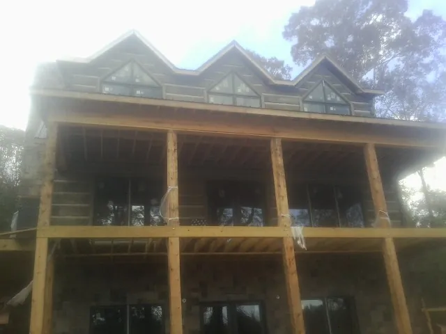 Dormers and porch framing on a large log home under construction — Roof Coating work by our crew in East Ellijay